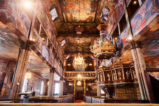 Insidan av Habo kyrka. Insidan är klädd i trä och målningar.
