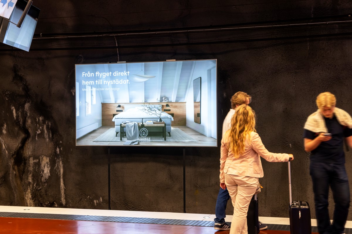 Sk&auml;rm med belysning p&aring; en v&auml;gg p&aring; en tunnelbanestation.