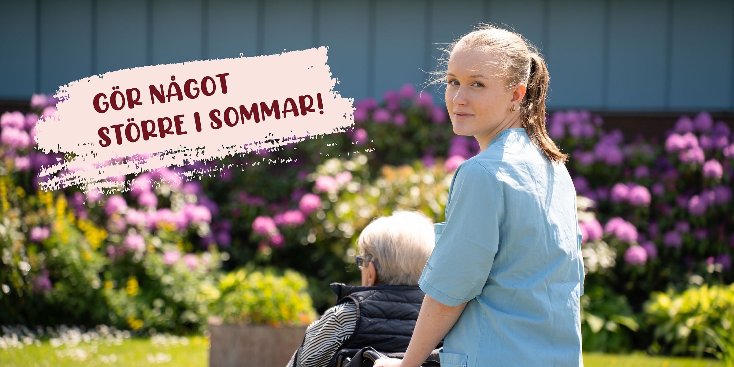 En sommarobbare kör en äldre dam i rullstol.