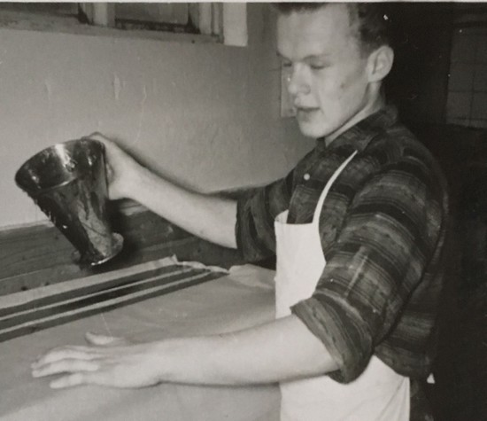 Svartvit bild på en ung man i förkläde.