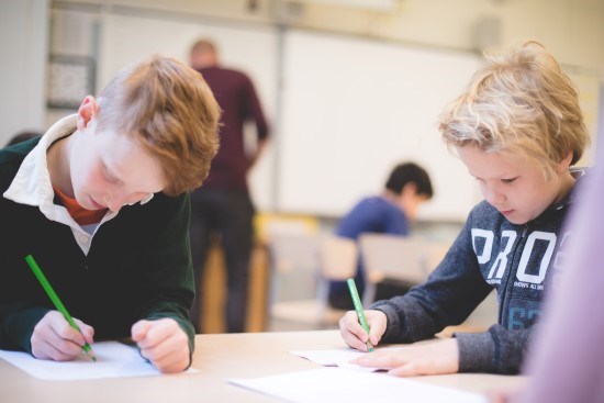 Två barn som sitter i skolan.