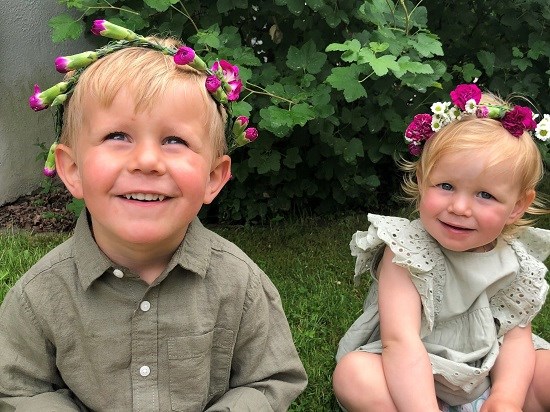 Flicka och pojk med blomsterkrans i håret