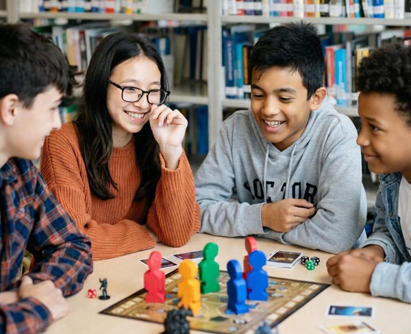 Fyra ungdomar runt ett brädspel