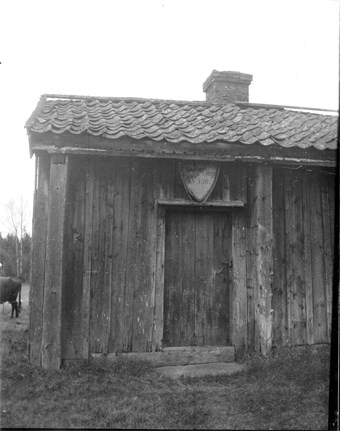 Ett svart/vitt foto av ett gammalt torp.